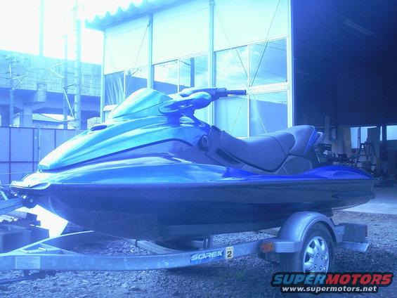 Blue jet ski on a trailer, side view. Trailer has 'SOREX 2' text